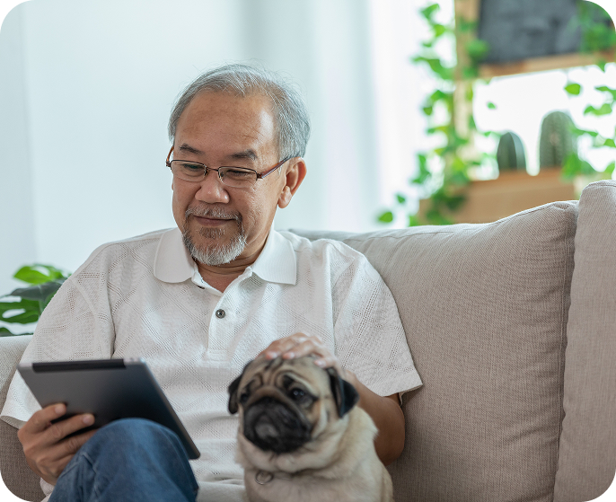 senior man sitting with dog on couch