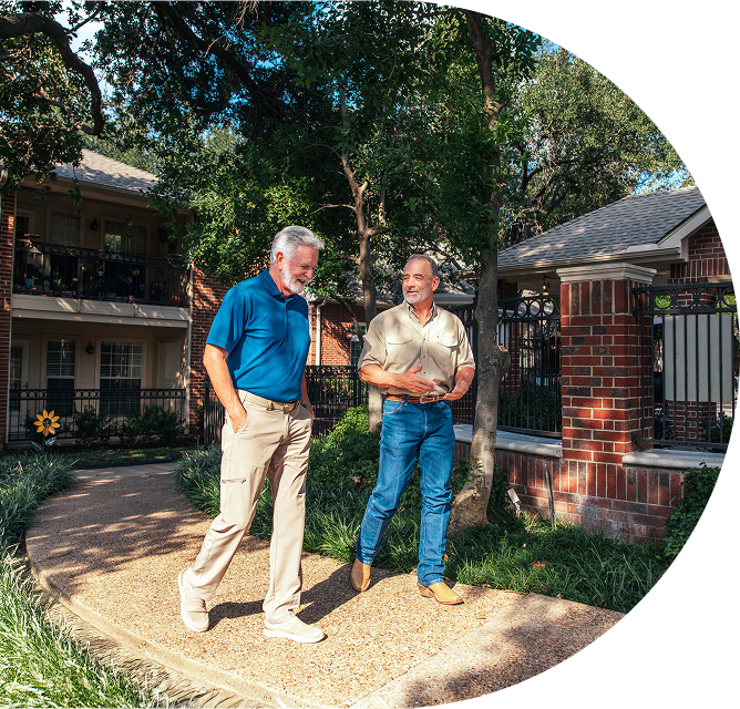 senior friends walking landscaped pathway